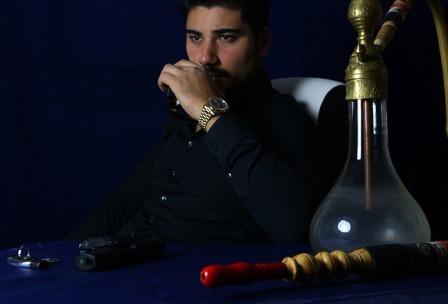 The man with black shirt and having hookah